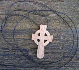 Carved wooden celtic cross on a leather thong